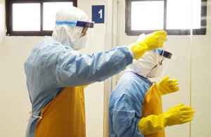 Doctors help each other with their protective suits during an Ebola virus drill at the Doctor Ramon de Lara hospital in the Dominican Air Force base at Santo Domingo