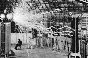 Nikola Tesla sitting in his laboratory with his Magnifying Transmitter