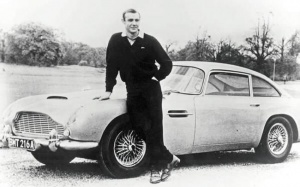 Sean Connery as James Bond, poses with Aston Martin DB5 – 1965