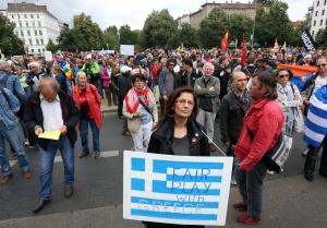 A protestor holds a sign reading "Fair Play With Greece" during a Blockupy demonstration in Berlin on June 20, 2015. Approximately 1,800 demonstrators marched for support of Greece amidst the country's economic crisis as well as for aid to refugees coming to Europe.   AFP PHOTO / ADAM BERRY