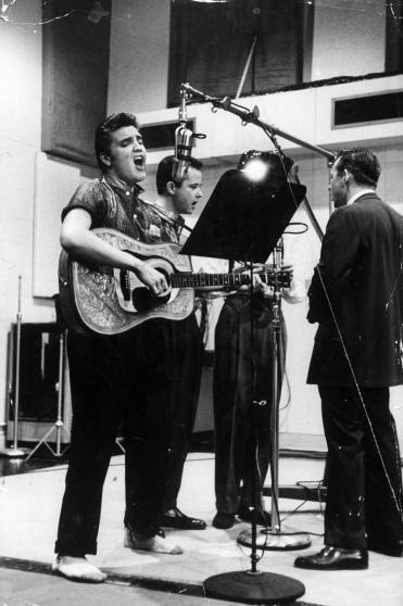 Elvis Presley recording song in Nashville studio, agonizing expression on face, wearing sport shirt, holding guitar & singing new song after his record Heartbreak Hotel was best seller.  (Photo by Don Cravens/The LIFE Images Collection/Getty Images)