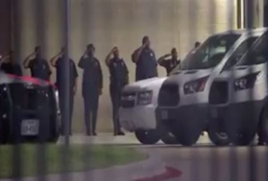 Dallas officers pay their respects as the bodies of the colleagues killed are transported