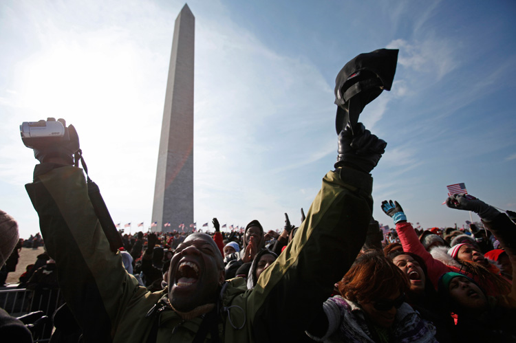 An attendee at the National Mall celebrates by the Washington Monument during the inauguration ceremony of Barack Obama as the 44th President of the United States in Washington
