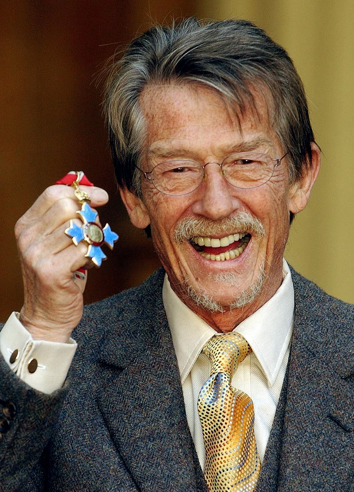 FILE PHOTO: British actor Hurt holds his CBE presented to him by Queen Elizabeth at Buckingham Palace in London.