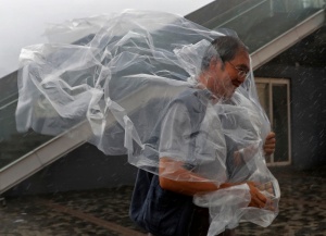 A man braves the wind on the waterfront of Victoria Habour as Typhoon Haima approaches Hong Kong, Friday, Oct. 21, 2016. Typhoon Haima churned toward southern China on Friday after smashing into the northern Philippines with ferocious wind and rain, triggering flooding, landslides and power outages. (AP Photo/Vincent Yu)